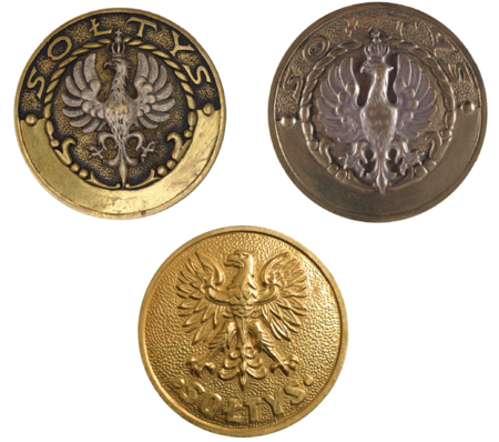 Dwie odznaki godności sołtysa, różniące się rysunkiem orła, z okresu II Rzeczypospolitej oraz odznaka funkcyjna sołtysa z okresu Polskiej
Rzeczypospolitej Ludowej – w myśl § 13 ust. 2 rozporządzenia Rady Ministrów z dnia 30 listopada 1972 roku w sprawie zasad i trybu, zakresu
działania oraz obowiązków i praw sołtysa i podsołtysa (Dz.U. 1972, Nr 49, poz. 319): Odznaka służbowa sołtysa jest metalowa, okrągła,
o średnicy 40 mm, z wizerunkiem orła pośrodku i napisem u dołu: „Sołtys”. Odznakę nosi sołtys na prawej stronie piersi
(Muzeum Narodowe w Krakowie, nr inw. MNK V-4626; nr inw. MNK V-6074; odznaka trzecia ze zbiorów prywatnych)